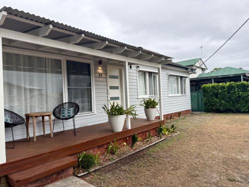 a porch of a house with two chairs and plants at Saltwater Escape in Swansea