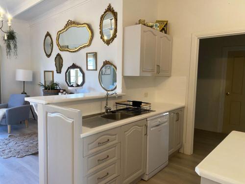 una cucina con un lavandino e specchi sul muro di Ducks & Drakes Outback House a Broken Hill