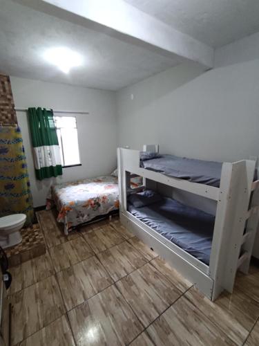 a room with two bunk beds and a bathroom at Bela Casa em Madre de Deus 2 in Madre de Deus