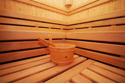 a bucket in a wooden sauna with a cup at Hotel International Prishtina & Spa in Pristina