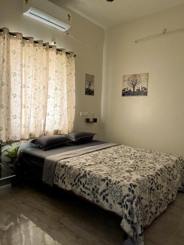 a bedroom with a bed and a window with curtains at Payaringal House Botanical Garden White Town Promenade Beach in Pondicherry