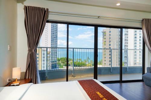 ein Schlafzimmer mit einem Bett und einem großen Fenster in der Unterkunft D26 Nha Trang Hotel in Nha Trang