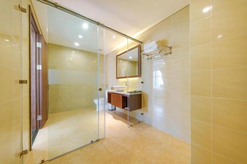 ein Badezimmer mit Dusche, Waschbecken und Spiegel in der Unterkunft D26 Nha Trang Hotel in Nha Trang