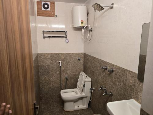 a small bathroom with a toilet and a sink at Hotel GT Galaxy in Chennai