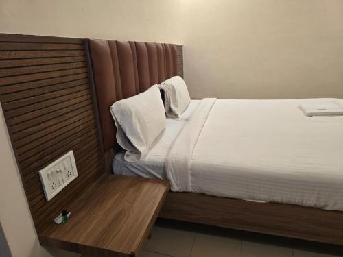 a bedroom with a bed with a wooden head board at Hotel GT Galaxy in Chennai