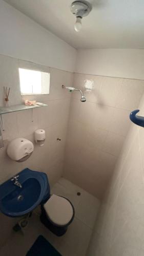 een badkamer met een blauw toilet en een wastafel bij Amanecer Costero in Santa Marta