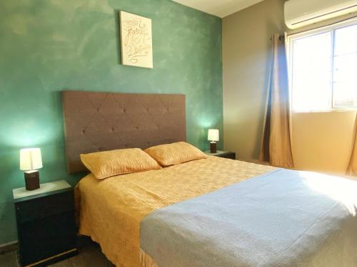 una camera da letto con un letto grande e una finestra di Departamentos Raices - Jardines del Lago a Mexicali