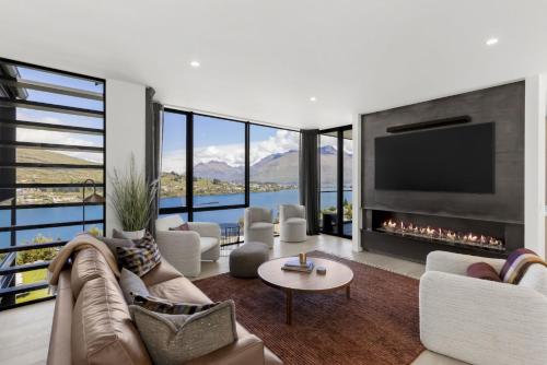 a living room with a fireplace and a tv at Belle Vue Villa - Stunning Views with Hot Tub in Queenstown