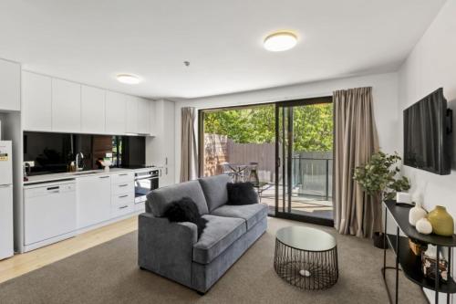 a living room with a couch and a table at Charming-on-fryer-central-apt-and-walk-to-town in Queenstown