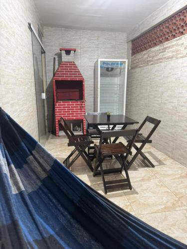 a patio with a table and chairs and a fireplace at Refúgio Beira Mar Na Praia da Tartaruga in Rio das Ostras