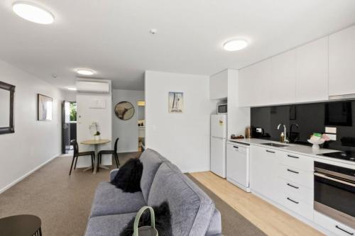 a living room with a couch and a kitchen at Charming-on-fryer-central-apt-and-walk-to-town in Queenstown