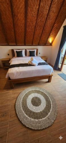 una camera con un letto e un tappeto sul pavimento di Pondok Kanginan a Plaga