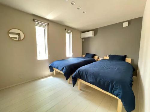 twee bedden in een slaapkamer met blauwe dekbedden bij Ippuku - Vacation STAY 17436 in Kanazawa