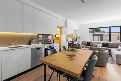 a kitchen and living room with a wooden table and chairs at Mountain Views Penthouse - Apartment 22 in Queenstown