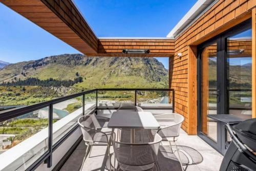 a balcony with tables and chairs and a view of a mountain at Mountain Views Penthouse - Apartment 22 in Queenstown