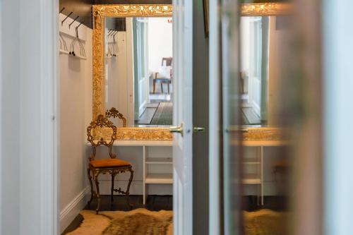 a hallway with a mirror and a chair in a room at The Globe in Castlemaine