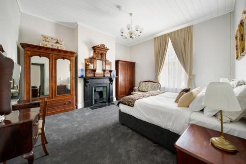 a large bedroom with a bed and a fireplace at The Globe in Castlemaine
