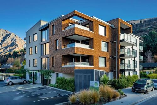 an image of an apartment building with a parking lot at Suki Apartment at the base of Coronet Peak in Queenstown