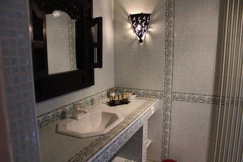 een badkamer met een wastafel en een spiegel bij La Villa Florida in Dieppe