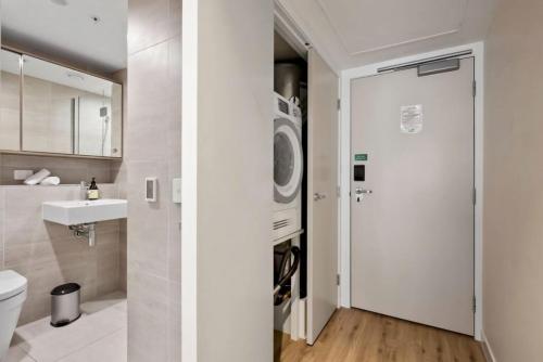 a bathroom with a washer and dryer next to a sink at Suki Apartment at the base of Coronet Peak in Queenstown