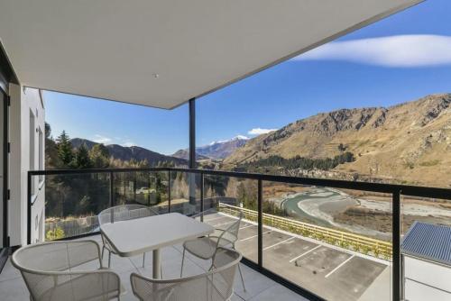a balcony with a table and chairs and mountains at Rihir Apartment at the base of Coronet Peak in Queenstown