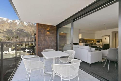 a living room with a white table and chairs on a balcony at Rihir Apartment at the base of Coronet Peak in Queenstown