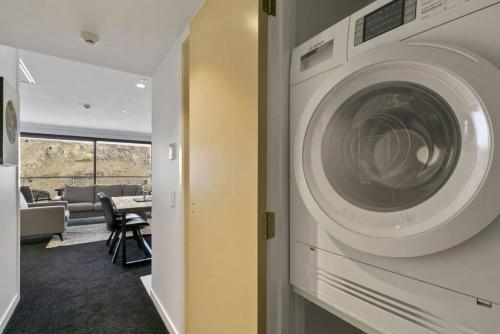 a washer and dryer in a living room at Rihir Apartment at the base of Coronet Peak in Queenstown