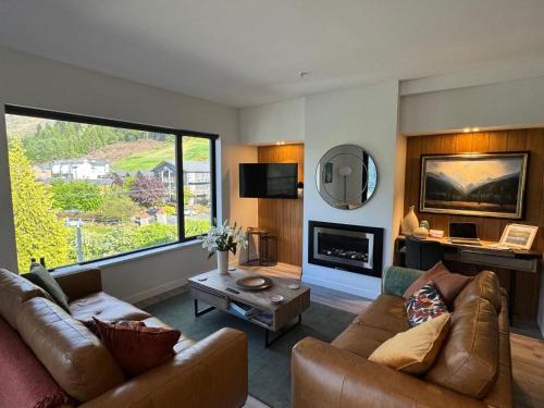 a living room with a couch and a fireplace at Riverview Penthouse - Apartment 19 in Queenstown