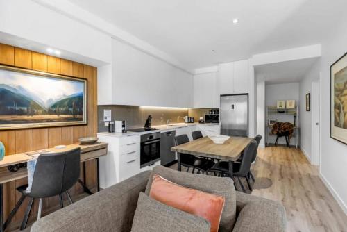 a kitchen and living room with a couch and a table at Riverview Penthouse - Apartment 19 in Queenstown