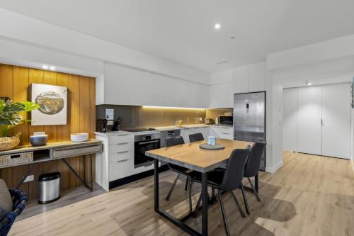a kitchen with a table and chairs in a room at Residence Du Parc - Apt 6b at the base of Coronet Peak in Queenstown