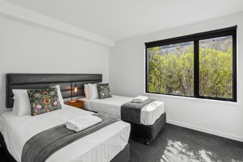 a hotel room with two beds and a window at Residence Du Parc - Apt 6b at the base of Coronet Peak in Queenstown