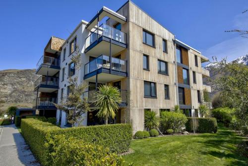 an apartment building with bushes in front of it at Residence Du Parc - Apt 6b at the base of Coronet Peak in Queenstown