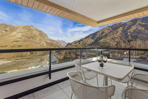 a balcony with a table and chairs and mountains at Residence Du Parc - Awa Apt 16a in Queenstown