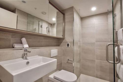 a bathroom with a sink and a toilet and a shower at Residence Du Parc - Awa Apt 16a in Queenstown