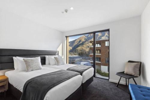 a hotel room with two beds and a large window at Residence Du Parc - Awa Apt 16a in Queenstown