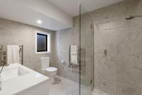 ein Badezimmer mit Waschbecken, Toilette und Dusche in der Unterkunft A Surprise on Sunrise - luxury with sauna and spa in Queenstown