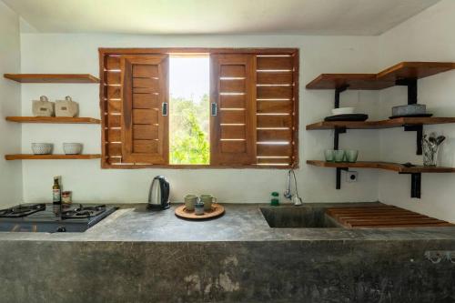 een keuken met een gootsteen en een raam erin bij Villa Tropical A in Uluwatu