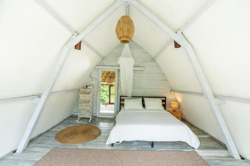 een slaapkamer met een bed op zolder bij Villa Tropical A in Uluwatu