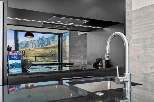 a kitchen with a sink and a window with a mountain view at St Marks Stunning Views Queenstown in Queenstown