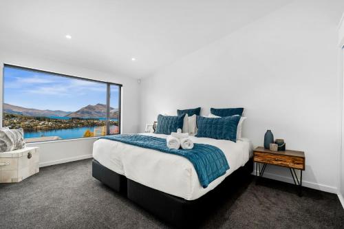 a bedroom with a large bed and a large window at St Marks Stunning Views Queenstown in Queenstown