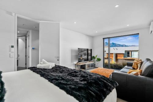 a bedroom with a large bed and a couch at St Marks Stunning Views Queenstown in Queenstown