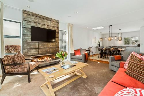 a living room with a couch and a fireplace at Central Queenstown 3 Bed Villa in Queenstown