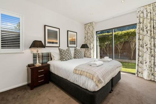 a bedroom with a large bed and a window at Central Queenstown 3 Bed Villa in Queenstown