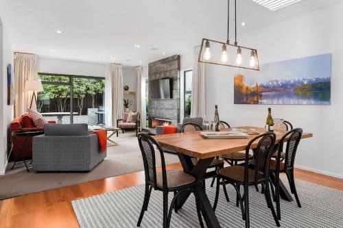 a dining room and living room with a table and chairs at Central Queenstown 3 Bed Villa in Queenstown