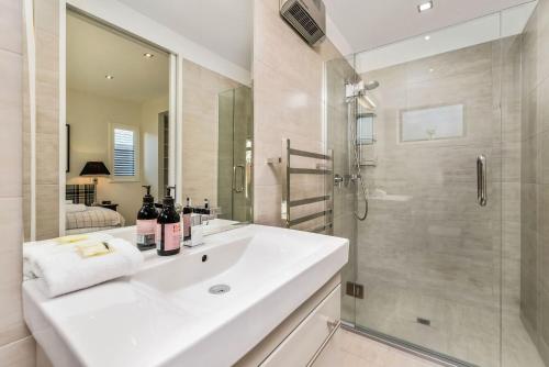 a white bathroom with a sink and a shower at Central Queenstown 3 Bed Villa in Queenstown