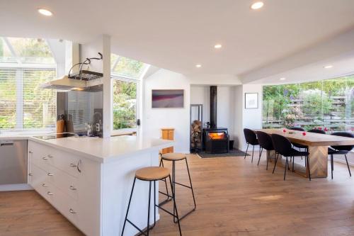 a kitchen and dining room with a table and chairs at Edinburgh 3BR 2BA with Hot Tub Views Fireplace in Queenstown