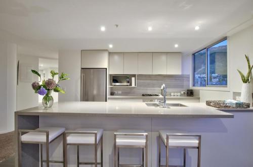 a kitchen with a island with bar stools at Bay View Condo in Queenstown