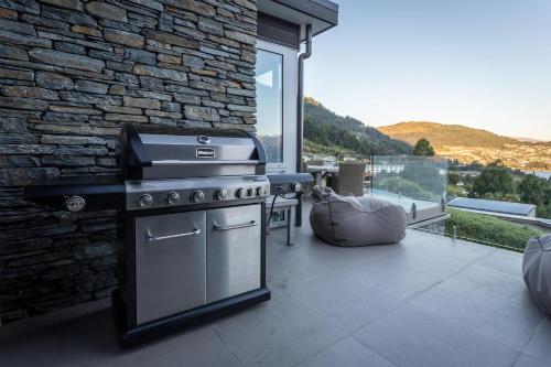 a outdoor kitchen with a stove and a stone wall at The Views and Spa 4BRM in Queenstown