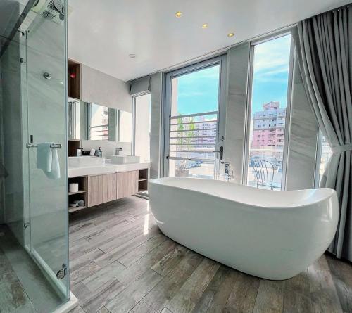 uma grande banheira branca em um banheiro com janela em Hotel Mapp em Taichung