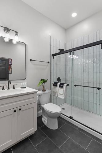 a white bathroom with a toilet and a shower at Studio Apt. Near Alamo Drafthouse, SLU & Downtown in Saint Louis